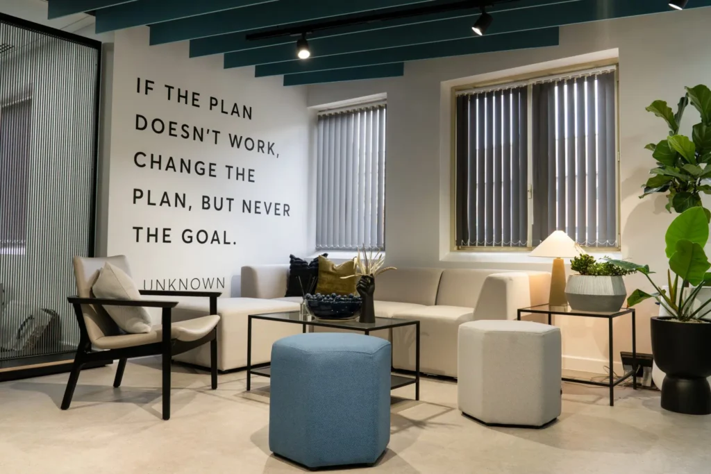 Entrance area with table, chairs, plants and text mural